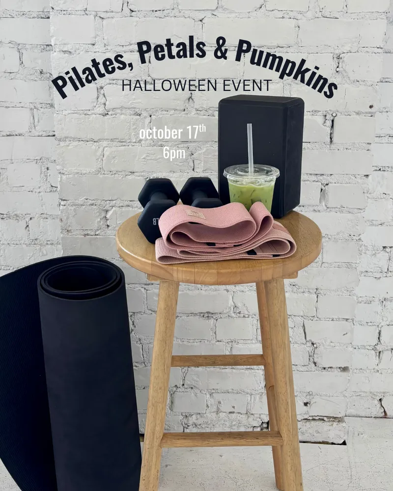 Event flyer for Pilates, Petals & Pumpkins, a Halloween event on October 17th at 6pm, showing dumbbells, a pink resistance band, a yoga block and an iced matcha on a wooden stool beside a rolled-up black mat